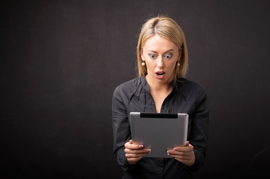 Woman looking at tablet in shock
