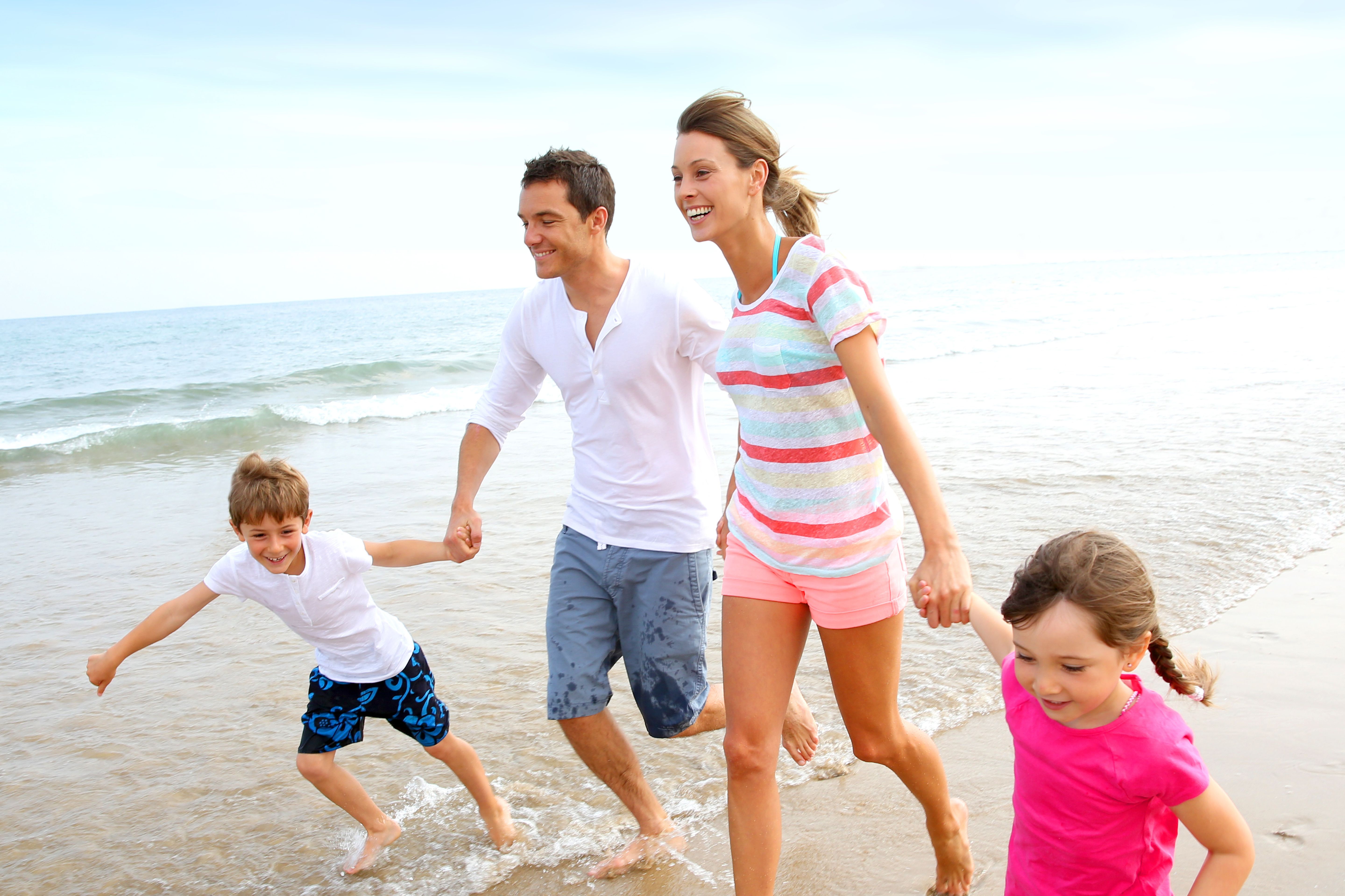 Happy family running on the beach