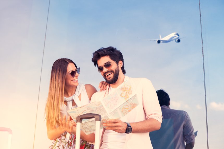Cheerful love young couple with city map on airport
