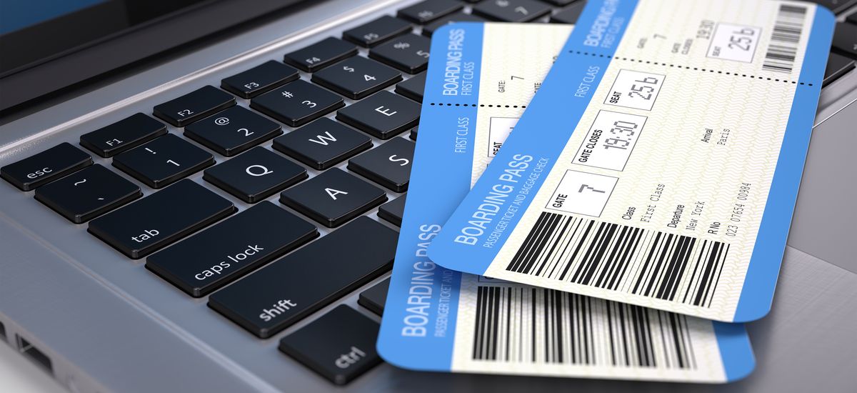 Two airline boarding pass tickets on laptop keyboard - online tickets booking concept