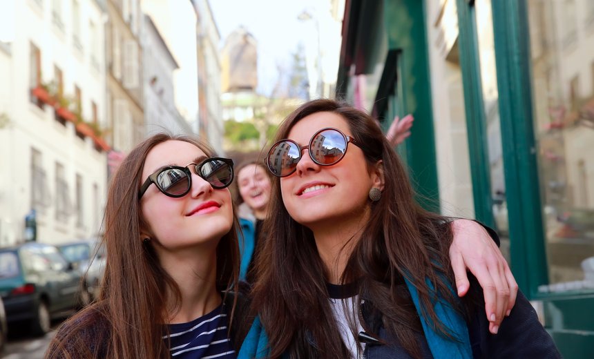 Happy beautiful student girls in Paris on the street