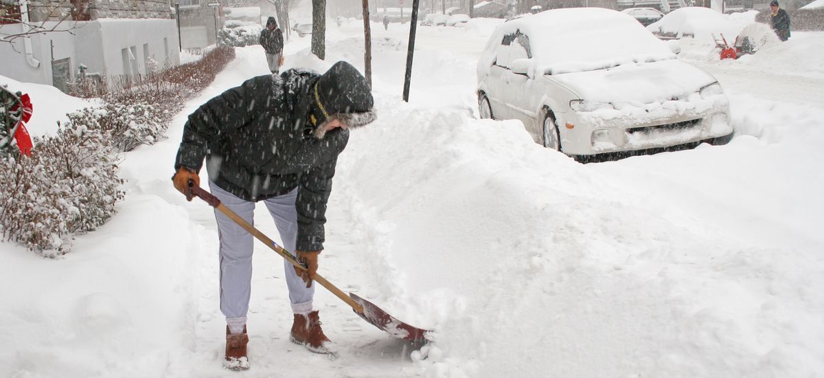 Woman shoveling after a snow storm. Canada.