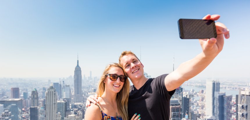 Young Couple Taking Selfie with New York on Background