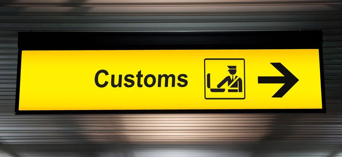 airport customs declare sign with icon and arrow hanging from airport ceiling at international terminal. customs declare for import and export concept