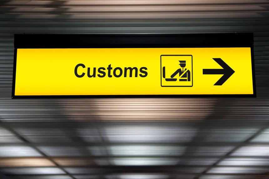 airport customs declare sign with icon and arrow hanging from airport ceiling at international terminal. customs declare for import and export concept
