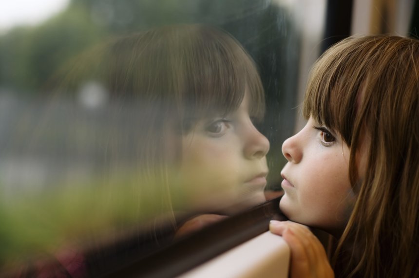Little girl looking through window
