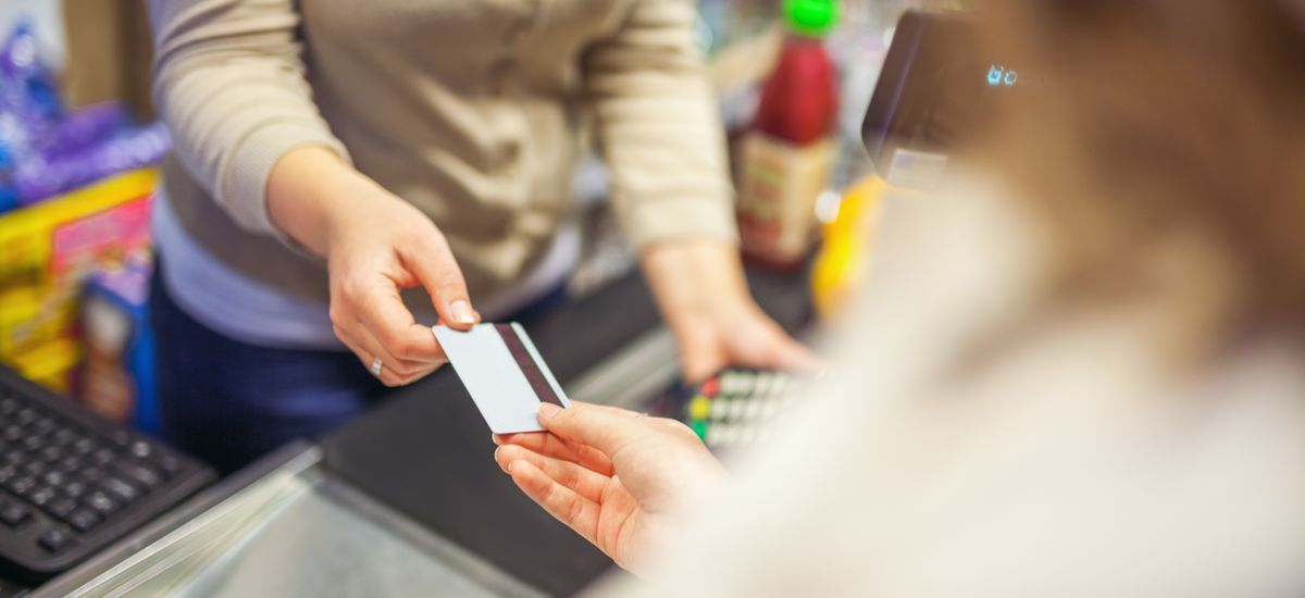 Woman paying with a credit card in a supermarket closeup