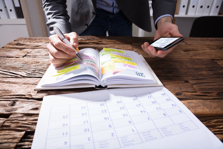 Businessperson Writing Schedule In Diary