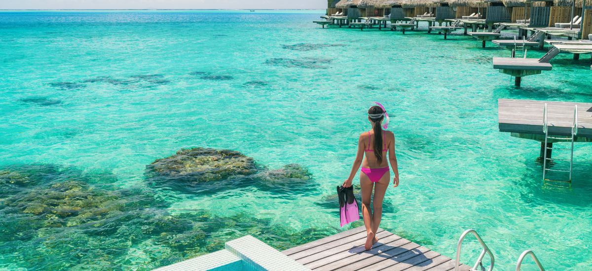Luxury overwater bungalows Tahiti resort woman going snorkeling 