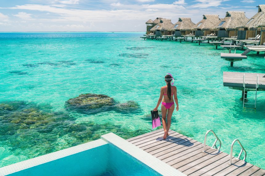 Luxury overwater bungalows Tahiti resort woman going snorkeling 