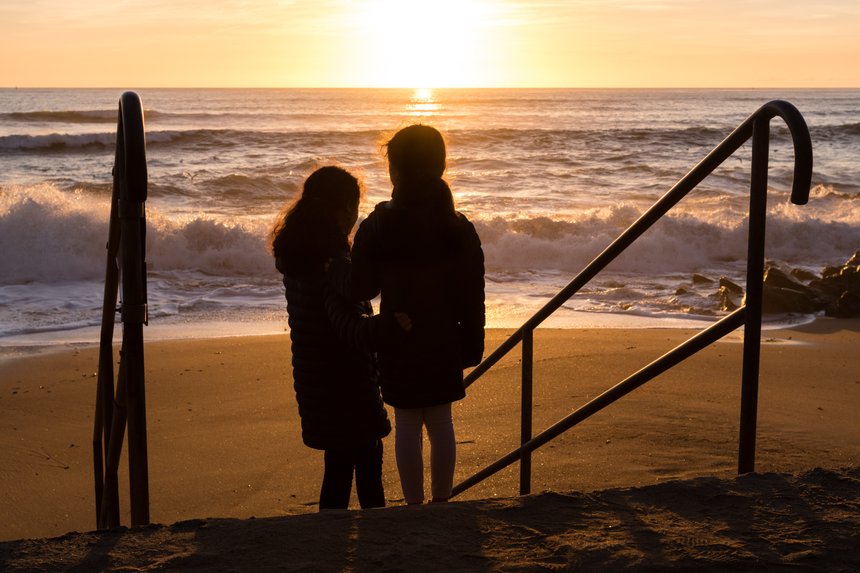 Enfants regardant un coucher de soleil Ã  la mer aux Sables d'Olonne