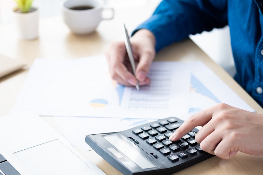 Businessman is inspecting and checking the business reports graphs to audit the financial reports by calculating the results. Analyzing the revenue and auditing the budget concept.