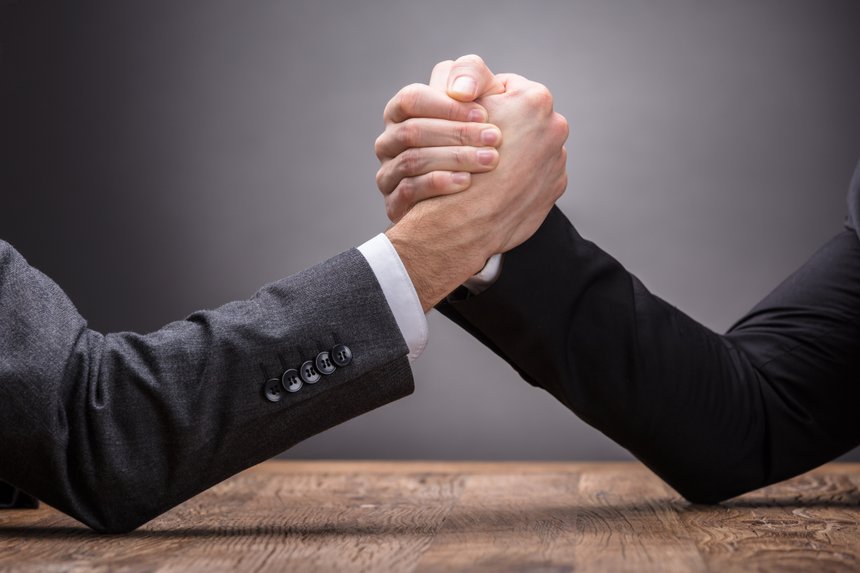 Two Businesspeople Competing In Arm Wrestling