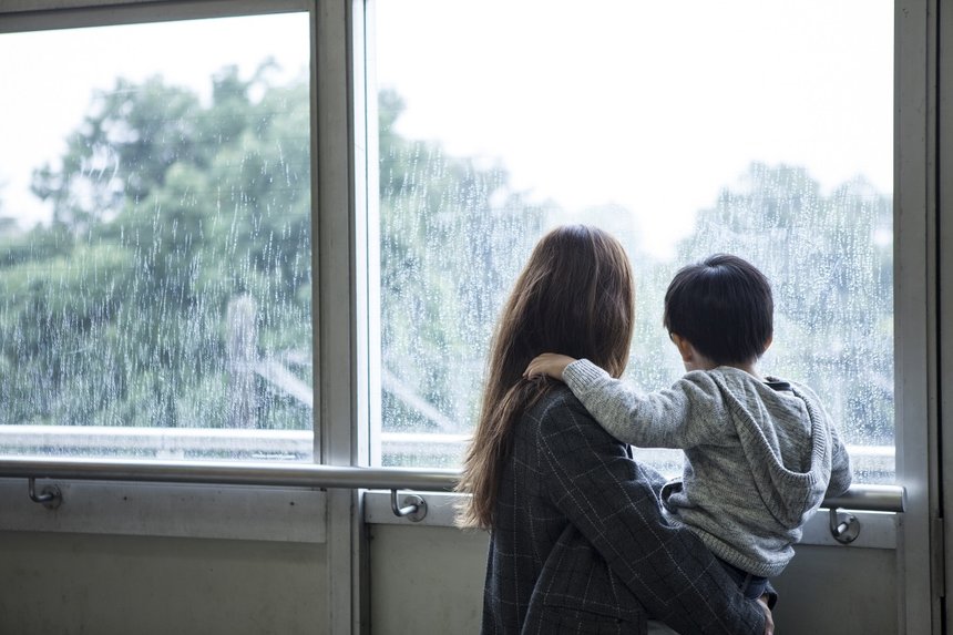 Mother is looking out of the window to hug his son