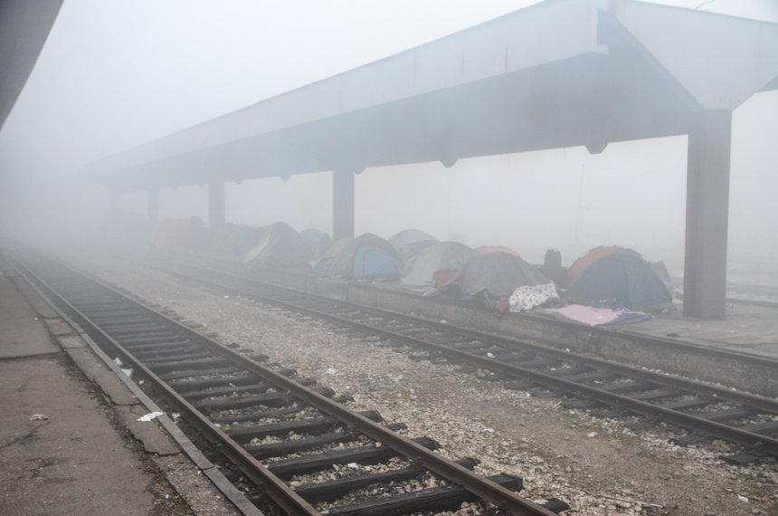 Thousands of refugees and migrants in Bosnia and Herzegovina trapped on Balkan route. Camp with tents on main railway station in Tuzla. Migrants are sleeping on streets during winter. Foggy day