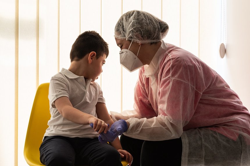 a physical therapist or nurse is talking to and caring for a young child with multiple disabilities in the clinic, rehabilitation center. coronavirus