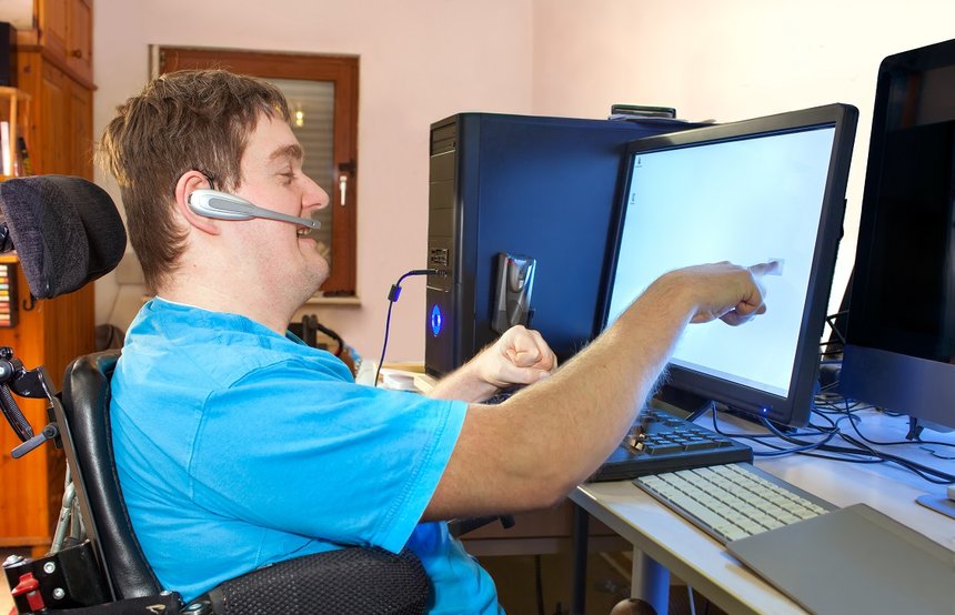 Man with infantile cerebral palsy using a computer.