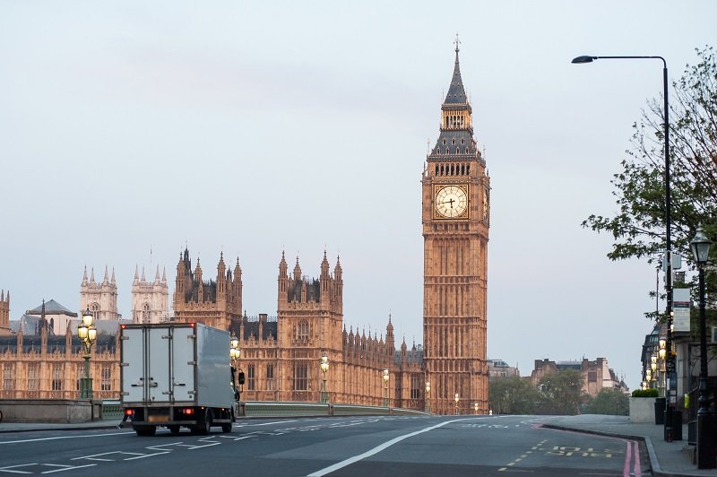 A delivery truck crosses Westminster Bridge at dawn in London. B