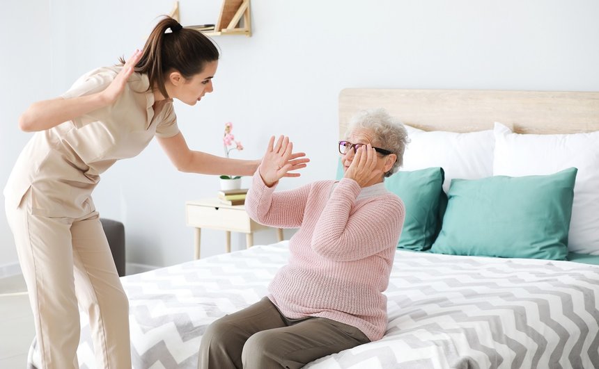 Caregiver mistreating senior woman in nursing home