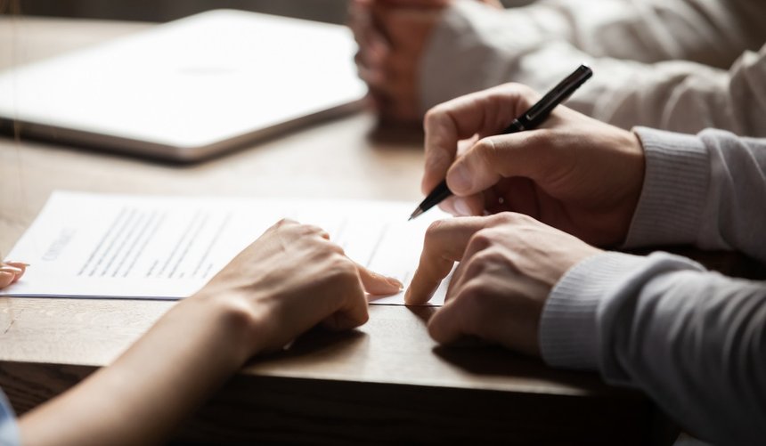 Solicitor pointing at contract showing client where to write sig