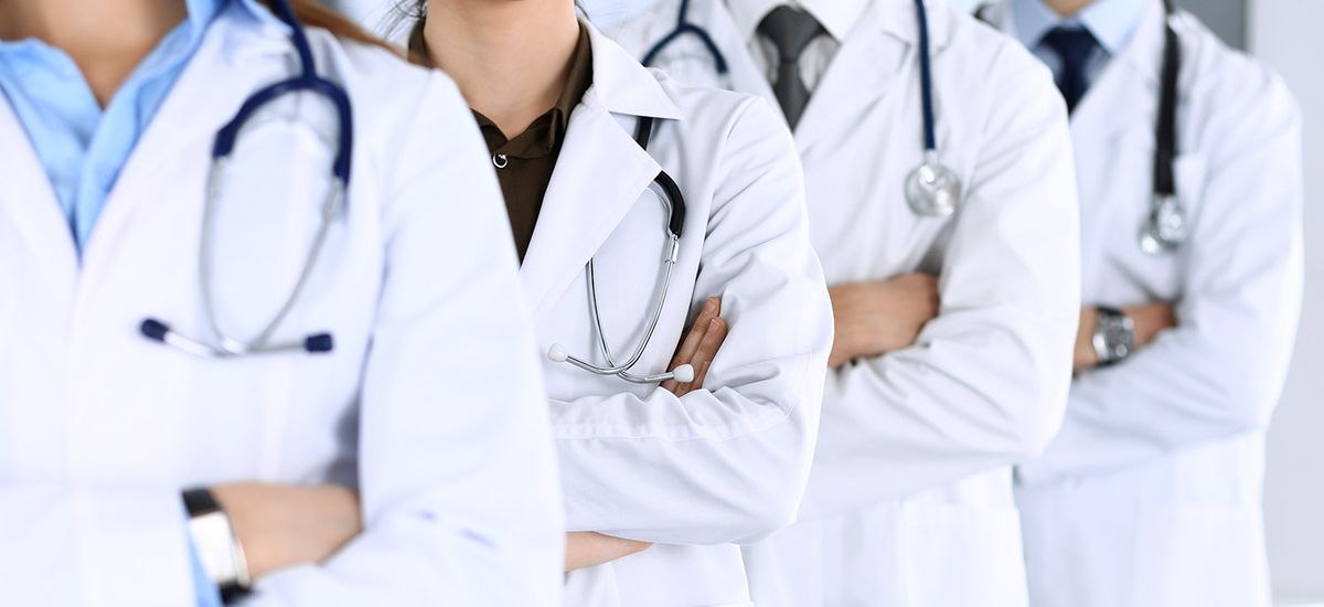 Group of modern doctors standing as a team with arms crossed in 