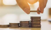 Hand putting coin stack step staircase on desk. Save money and i