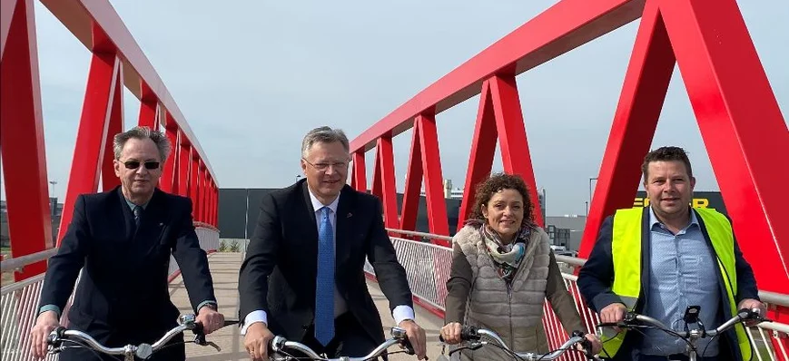 A vélo, sur un pont rouge, vers la zone fret de l'
