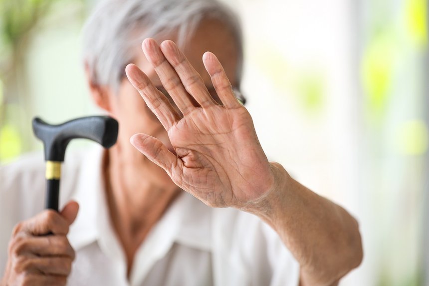 Asian senior woman making stop gesture with palm,against domesti