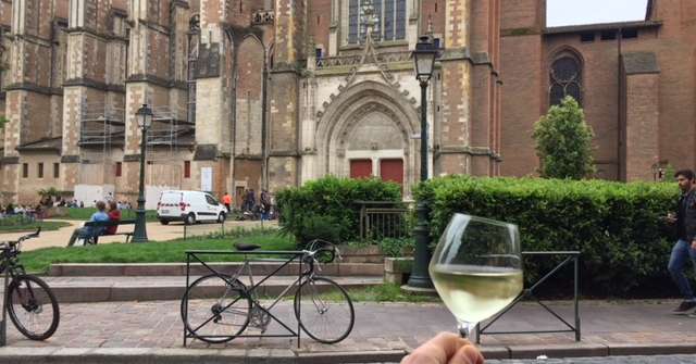 Paul Louis Coudoumie, un sommelier un verre à la main devant l'eglise Saint Cernin de Toulouse, un lieu incontournable de la ville rose. Credit photo : Paul-Louis Coudoumie