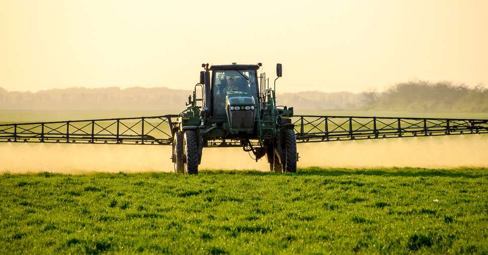 Tractor on the sunset background. Tractor with high wheels is ma