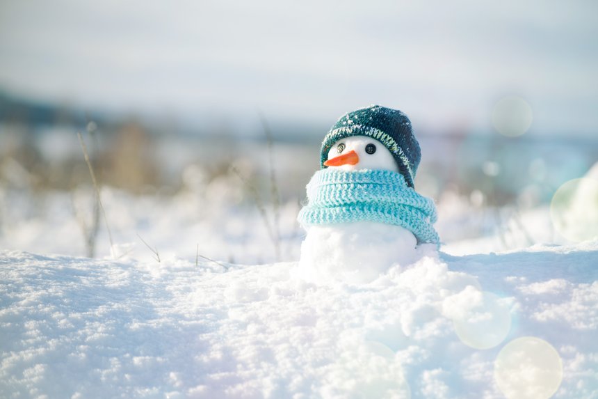 Little snowman in a cap and a scarf on snow in the winter. Chris