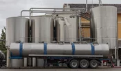 Stainless steel wine tanks and wine tanker waiting outside a factory