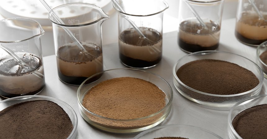 Glassware with soil samples and extracts on light table. Laborat