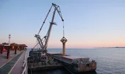 Transshipment of grain products from bulk carrier to the barge on Odessa, Ukraine anchorage during sunset