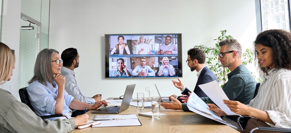 Diverse employees on online conference video call on tv screen i