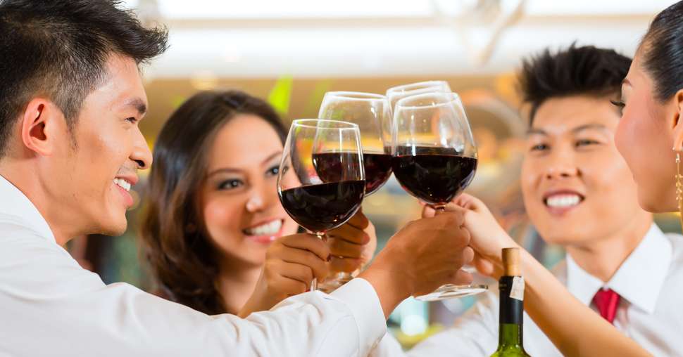 Chinese couples toasting with wine in restaurant