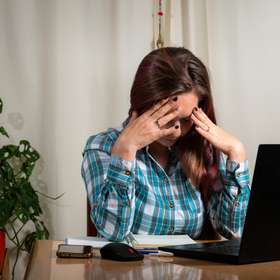 Mujer estresada de tanto trabajar con su computadora. Home Office y teletrabajo