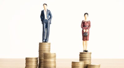 Wage difference between men and women concept. Man and woman standing on top of the pile of coins