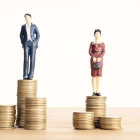 Wage difference between men and women concept. Man and woman standing on top of the pile of coins