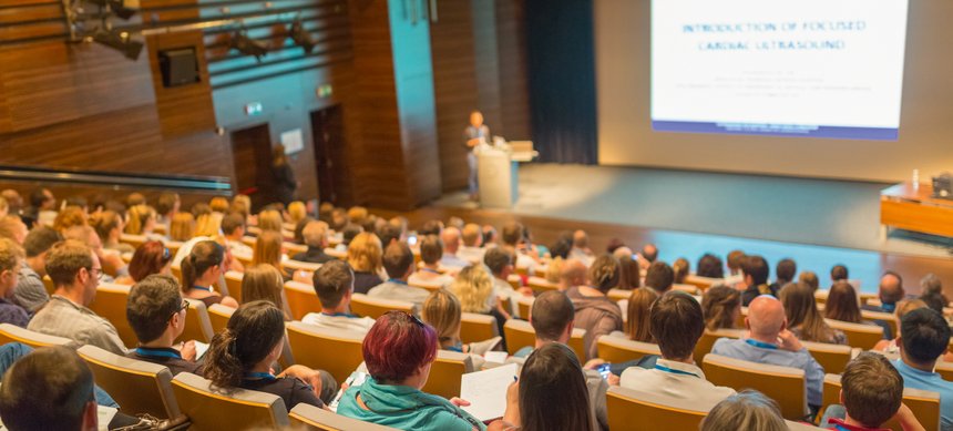 Business speaker giving a talk in conference hall.