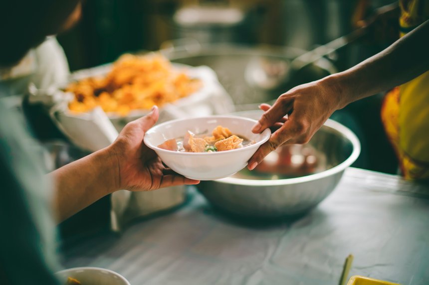 People holding a plate receiving a donation from a good friend,